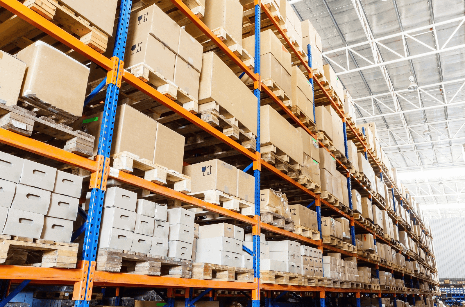 Pallets and boxed stock stored on warehouse shelving